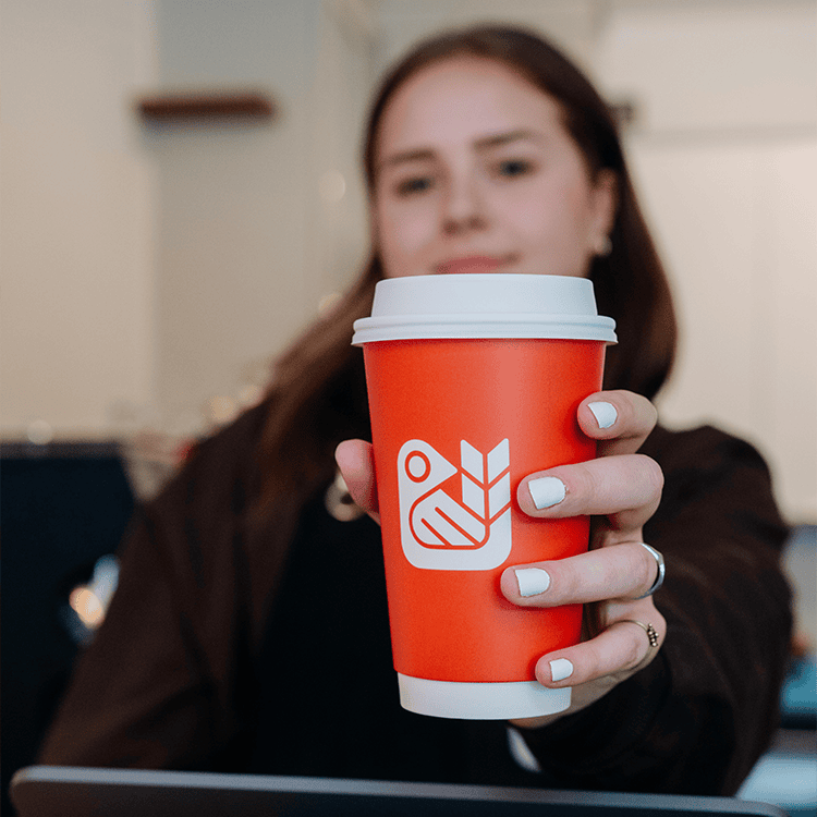 barista holding a red bird roasting to go cup